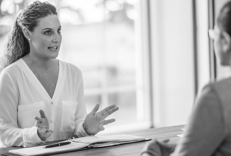 Adviser behind desk helping woman